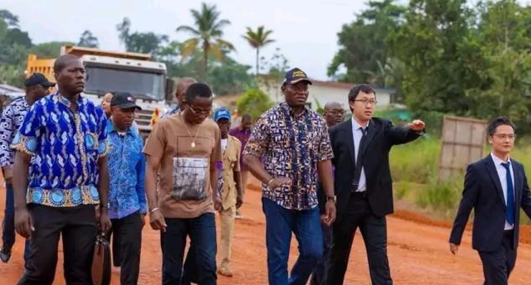 Convoi de véhicules officiels circulant sur une route en construction dans la province du Woleu-Ntem