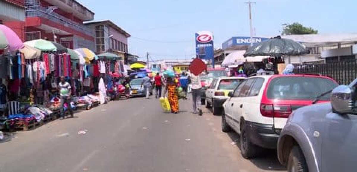 Rue animée de Libreville avec des commerces et étals en bord de route