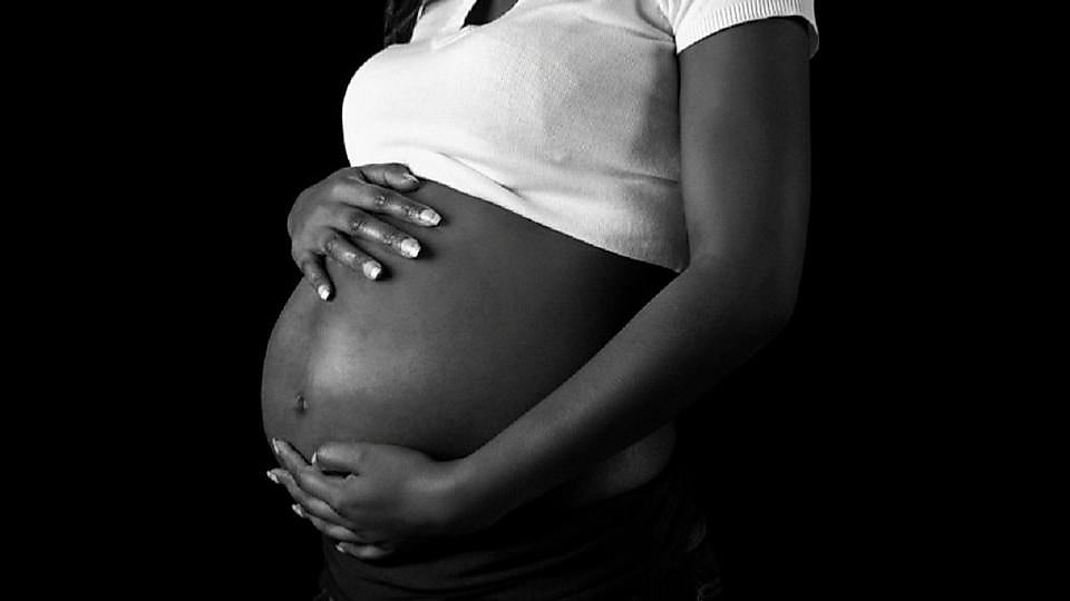 Femme enceinte protégée par une moustiquaire dans sa chambre