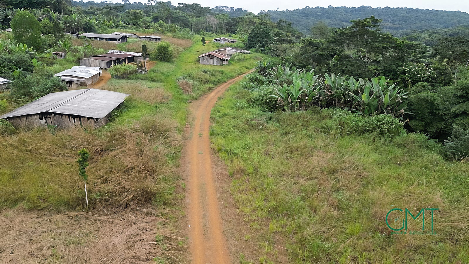 Piste en terre menant à un village rural entouré de végétation dense en Ngounié.