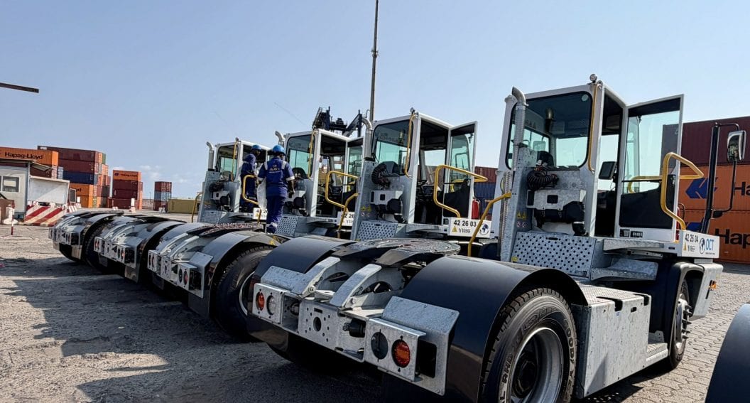 Tracteur portuaire tirant une remorque chargée de conteneurs sur un terminal maritime