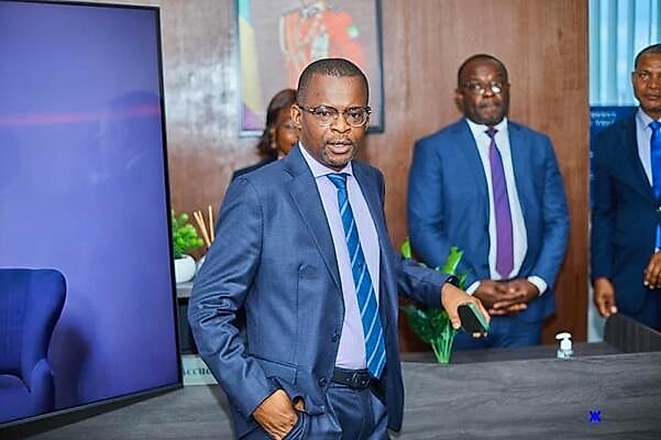 Ingénieur gabonais en tenue de travail sur un site pétrolier au coucher du soleil