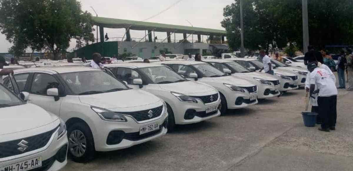 Des taxis neufs aux couleurs du programme Gab+ garés en ligne lors d'une cérémonie officielle