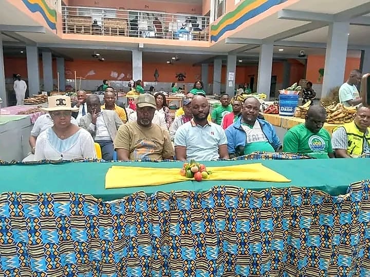Un élu remet un équipement à des vendeuses sur un marché en plein air au Gabon