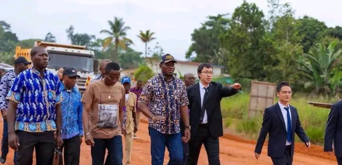 Convoi officiel roulant sur une route en travaux dans une zone forestière du nord du Gabon