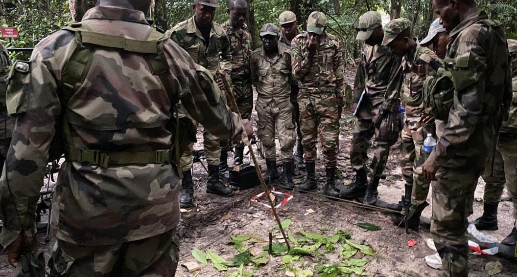 Militaires en treillis dans un champ agricole au Gabon