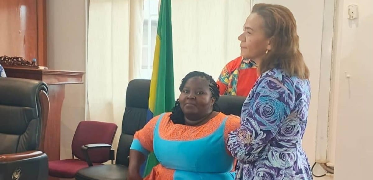 Salle de cérémonie officielle avec drapeau gabonais, illustrant l'installation d'un bureau professionnel