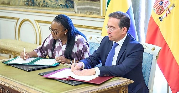 Deux responsables diplomatiques se serrent la main devant les drapeaux du Gabon et de l'Espagne